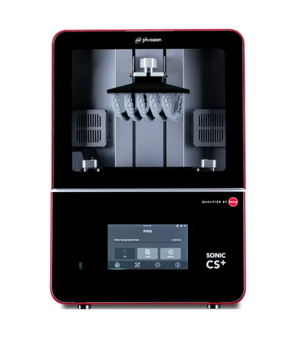 Inside a red-framed Phrozen 3D printer, showing the build chamber with resin-arch supports and metal hardware centered under a black hood.