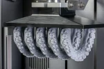 Row of gray dental cast models arranged under a dental scanning apparatus, ready for digital capture on a CAD/CAM system