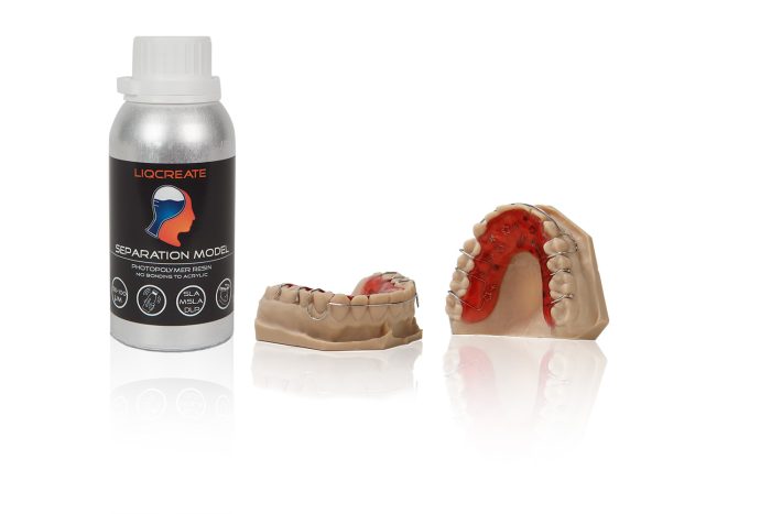 Bottle of separation-model resin beside two dental/her orthodontic models with braces on a white background.